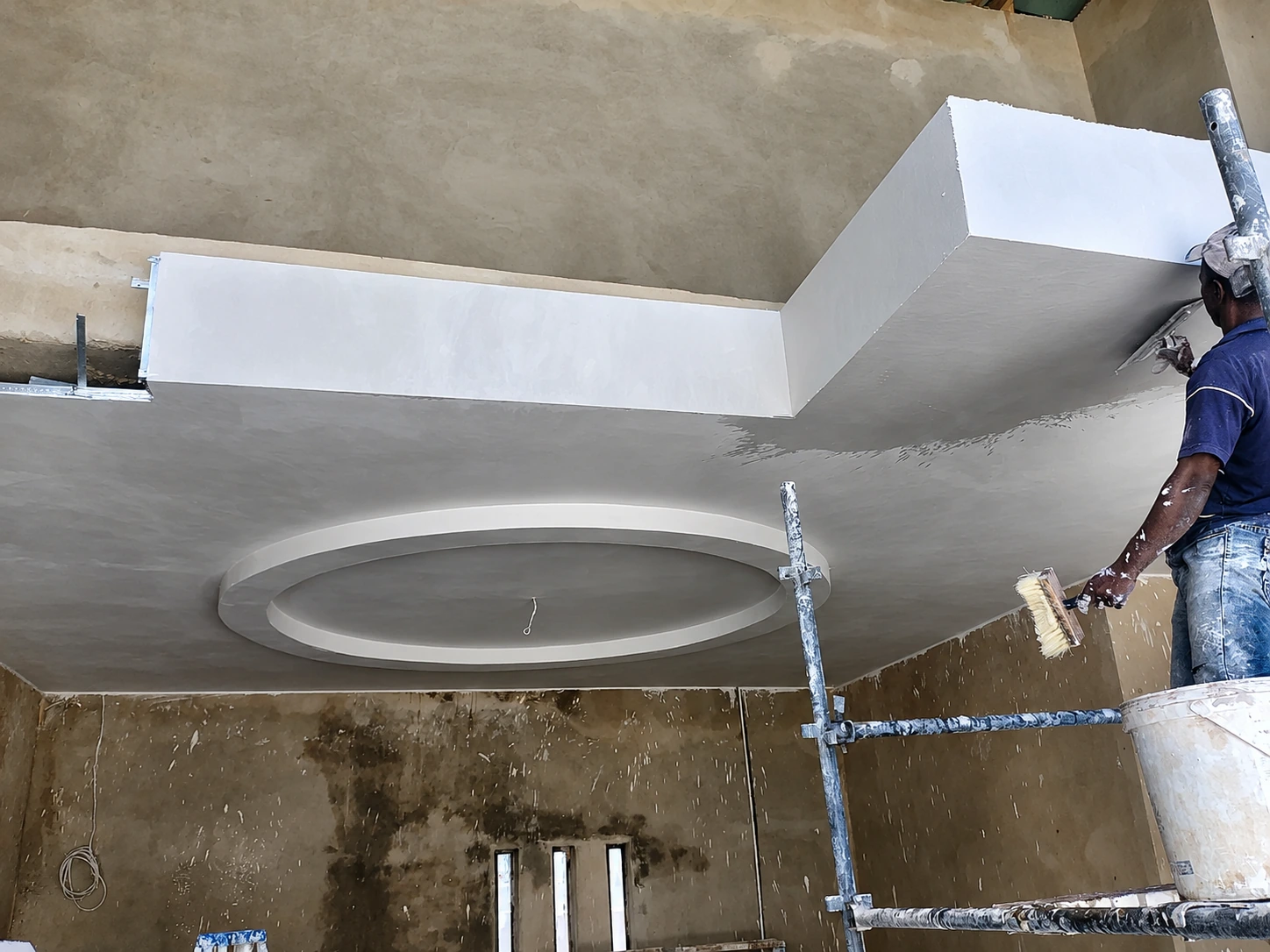 Specialist plastering a circular ceiling feature during installation